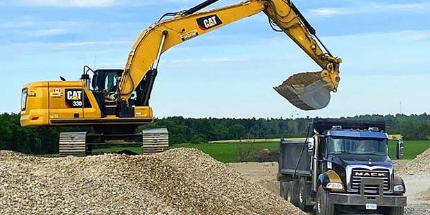 Excavator loading gravel into a dump truck.